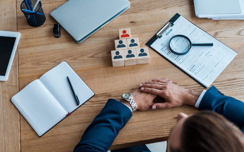 cropped view of man with clenched hands near wooden cubes